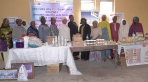 The UN Women Team and NFNV Nigeria members pose for a group photo before various displayed products of members of NFNV Nigeria